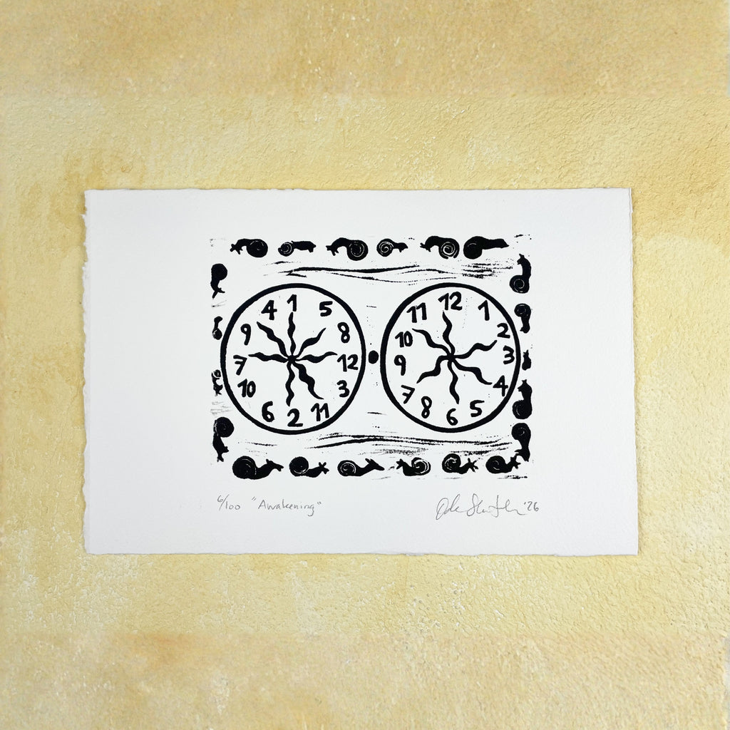 Black linocut "Awakening" with two clocks and snails, one clock ordered and one with jumbled numbers