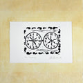 Black linocut "Awakening" with two clocks and snails, one clock ordered and one with jumbled numbers
