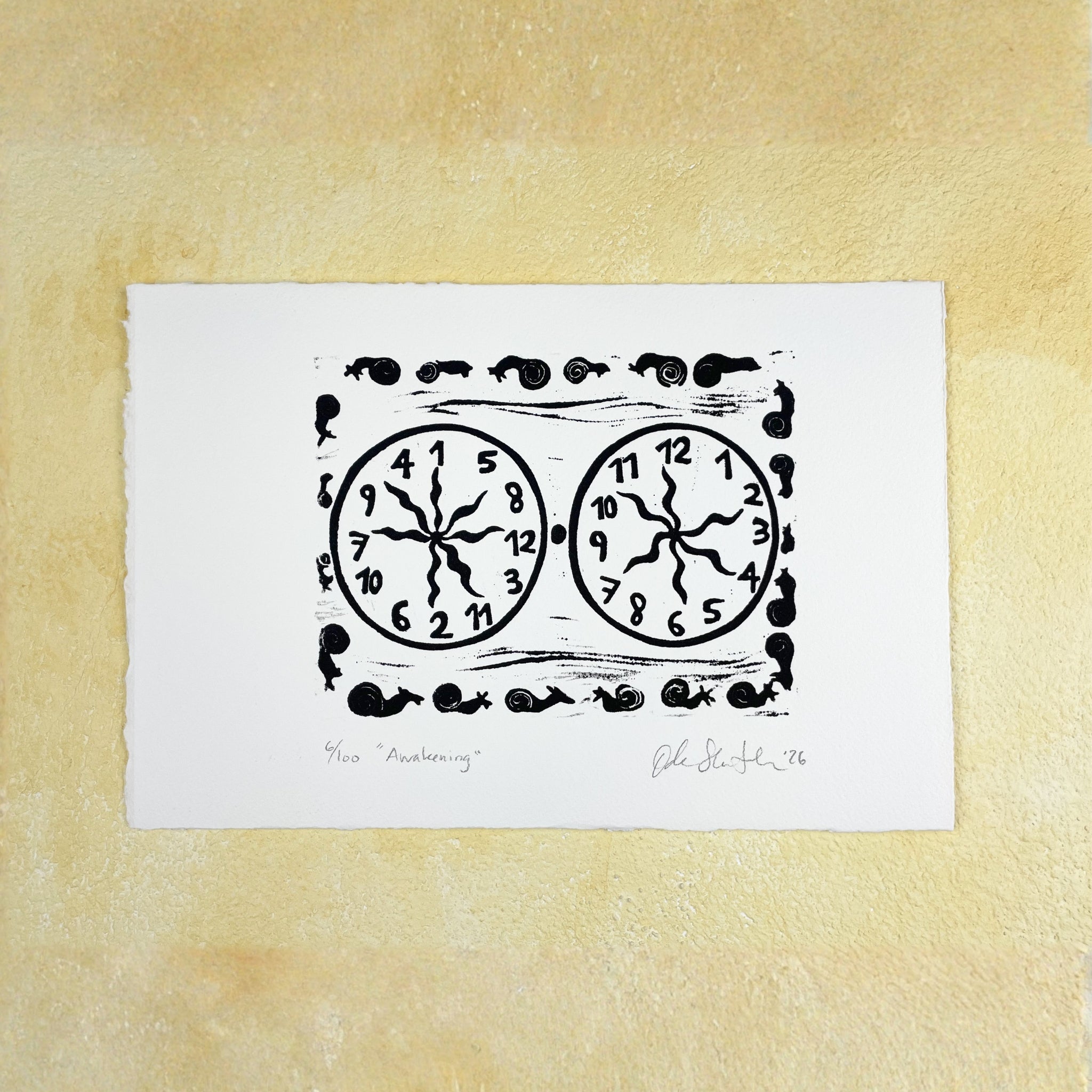Black linocut "Awakening" with two clocks and snails, one clock ordered and one with jumbled numbers
