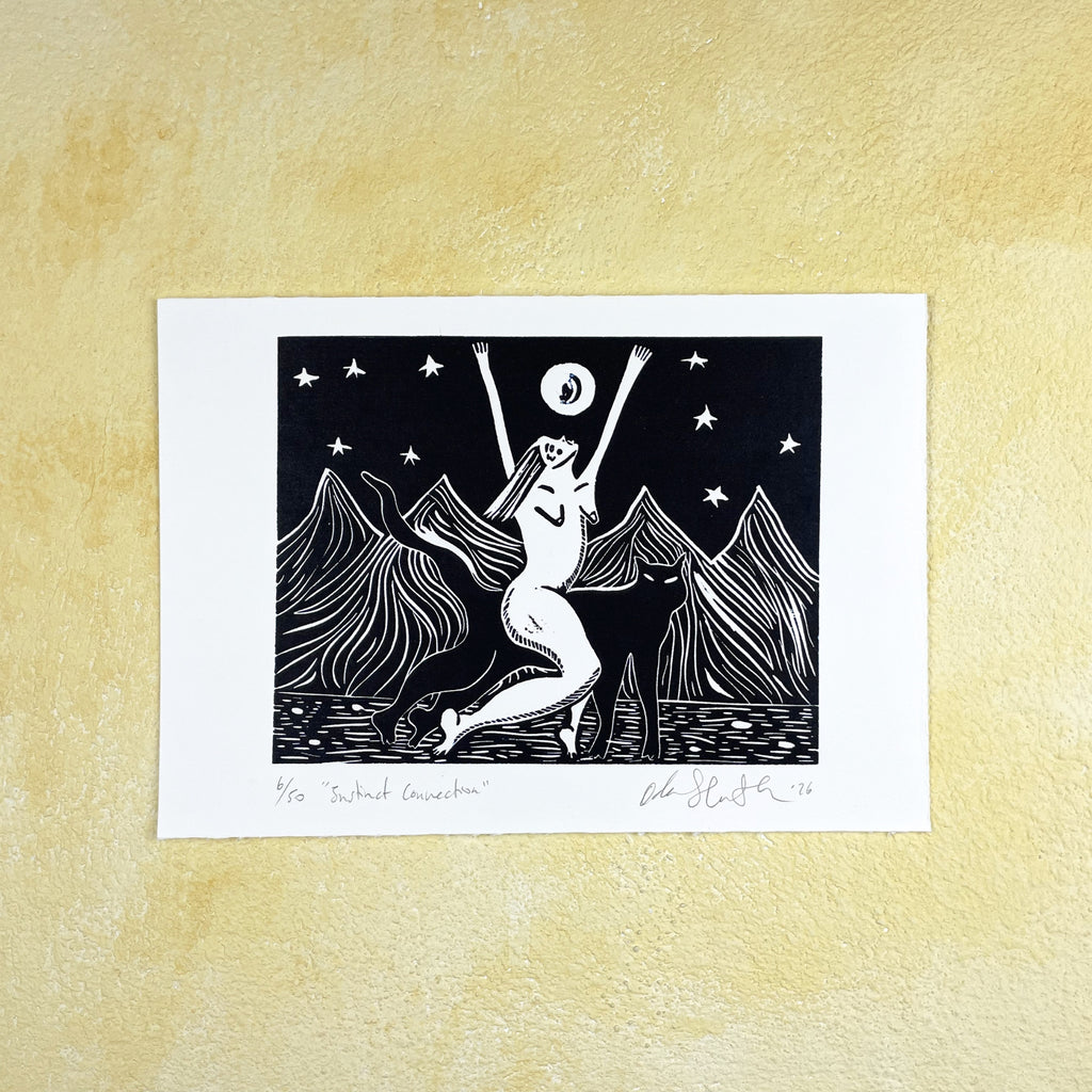 Black linocut print "Instinct Connection" of a stylized illustration of a woman riding a panther with arms raised against a mountain and starry sky background, on a beige textured surface. 